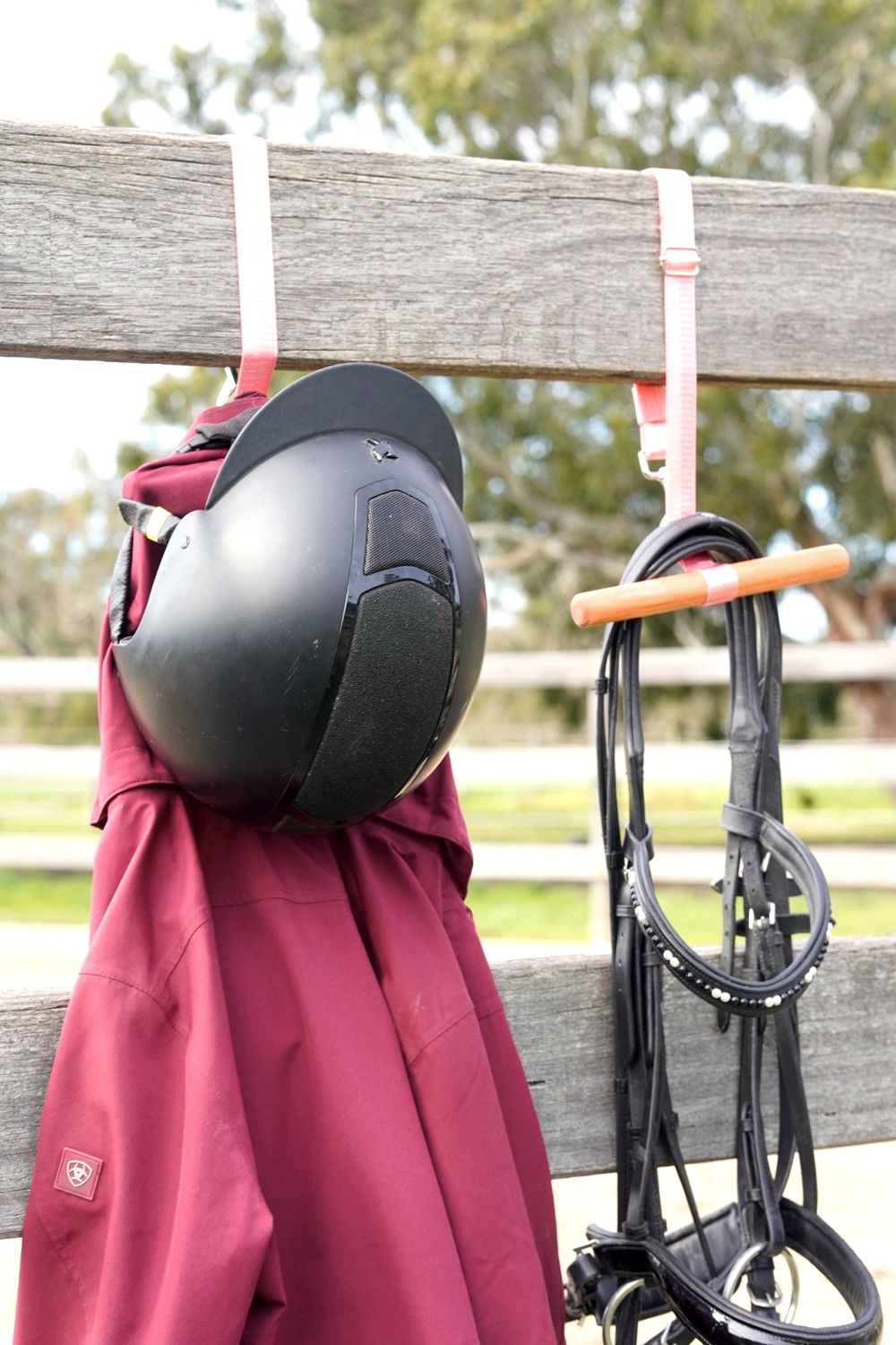 HIT Anywhere Hang holding a helmet, jacket and bridle on a fence rail